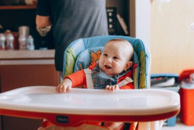 smiling baby in baby activity chair